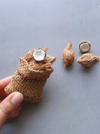 A close-up of a miniature sack of coconuts, a bonus creation from the vegetables course.