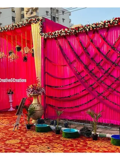 An outdoor setup featuring vibrant pink draped walls. The intricate patterns created with the fabric add texture and visual interest to the event's perimeter.