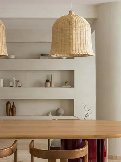 The dining area of the Tulum House, featuring oversized rattan pendants and built-in niches for display. The vibe is all about laid-back, earthy luxury.