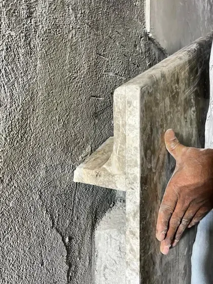 Craftsmanship is about shaping materials with intention. This image shows the process of creating a custom handrail from a single piece of stone on site. This detail, which also functions as a wall washer for lighting, is a testament to the skill of our team and our love for honest materials.
