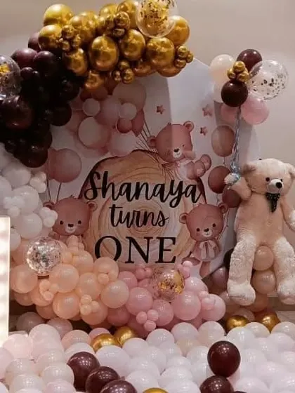 A teddy bear themed 'Shanaya turns ONE' party with a massive balloon setup and a large teddy bear prop.