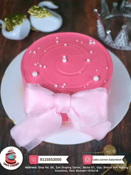 A pretty pink cake with a delicate fabric bow. The simple pearl details make this an elegant and charming choice for any celebration.