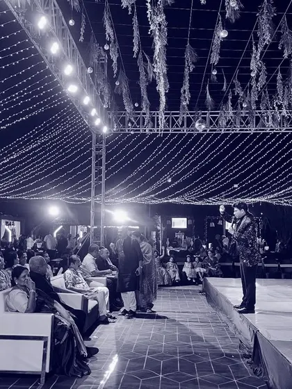 Another perspective of me on a large stage, addressing the audience. The scale of the lighting and setup shows the kind of grand events I am experienced in handling.