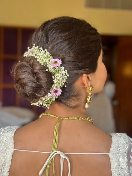 A detailed shot of the floral bun, featuring baby's breath and pink flowers. This shows the intricate work that goes into creating a beautiful floral hair accessory.