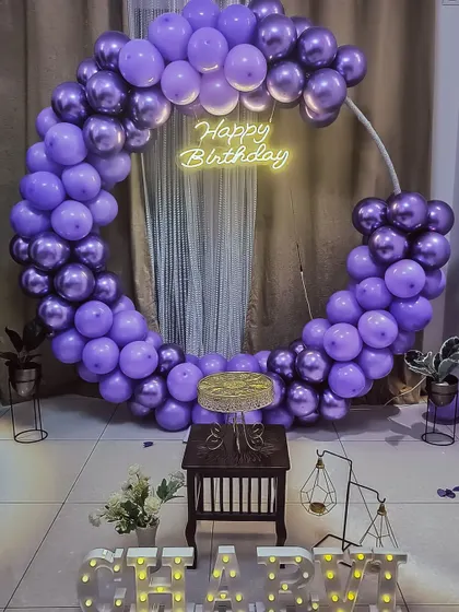 A gorgeous purple-themed birthday party. The full balloon ring in shades of lavender and chrome purple makes a bold statement.