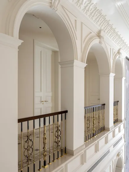The corridors of The Ivory Royale are designed with classical arches and ornate brass railings. Every detail, from the patterned marble floor to the intricate ceiling mouldings, contributes to a feeling of rich, quiet luxury.