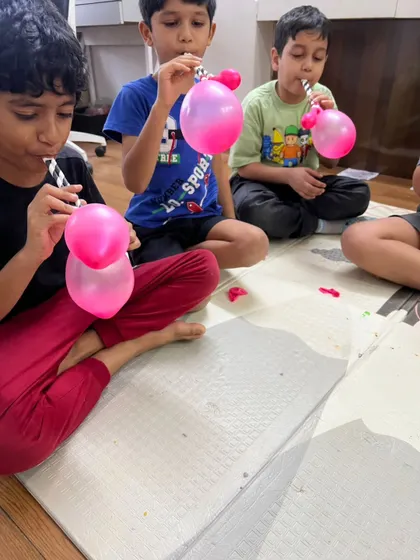 These boys are learning about lung capacity and air pressure by inflating double balloons, a fun and slightly challenging activity that always ends in giggles.