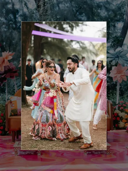 A candid shot of the couple dancing together at their outdoor Mehendi or Haldi function, surrounded by colorful decor.