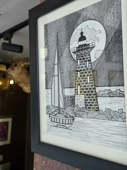 This pen and ink drawing of a sailboat by a lighthouse under a full moon is a beautiful piece from the "Vibing with Nature" exhibition. It showcases a different, more graphic style of landscape art.