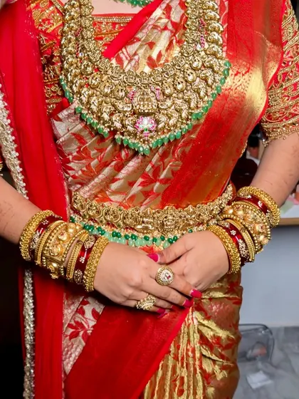 A close-up of the intricate details of the South Indian bridal attire, from the heavy temple jewellery to the rich silk of the saree.