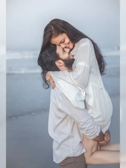 A joyful and romantic lift on the beach. This playful and intimate moment captures the couple's happiness and connection against the backdrop of the ocean.