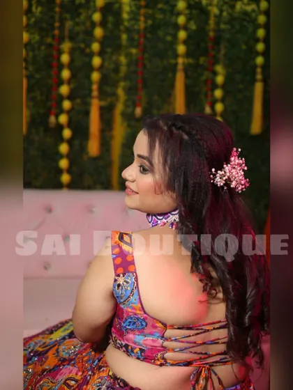 A close-up of the bride's beautiful backless blouse and hairstyle. The intricate design of the lehenga is perfect for a vibrant Mehndi celebration.