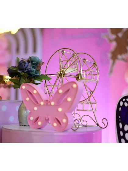 A close-up of a light-up butterfly prop and a miniature Ferris wheel.