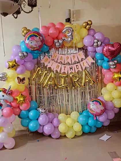 Another angle of the unicorn ring decoration, showing the full circle of balloons in yellow, pink, purple, and blue.