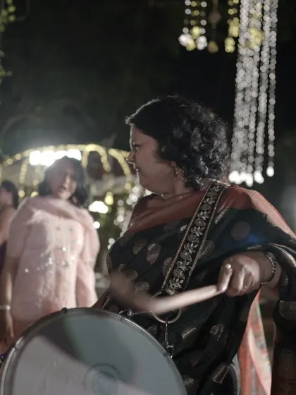 It's a celebration for everyone! A guest joins in the fun, playing the dhol and adding to the infectious energy of the Sangeet.