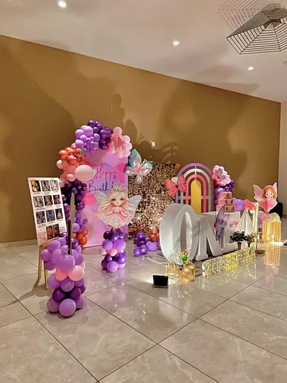 A clear shot of the left side of the butterfly setup, showing the photo board and a fairy cutout on a balloon pillar.