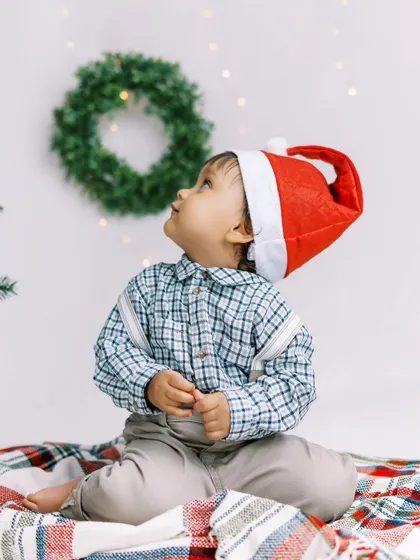 A little boy in a Santa hat, looking up at the Christmas lights. My studio-on-the-go allows me to capture these magical moments right in your home.