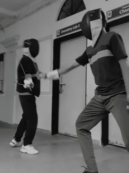 A black and white shot capturing the intensity of a close-quarters exchange between two fencers. This highlights the fast paced nature of the sport.