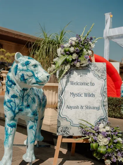 The welcome sign for the "Mystic Wilds" themed carnival, guarded by a beautifully painted leopard statue.