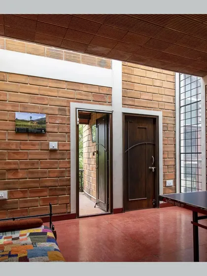 The warmth of natural materials defines this family space. Exposed brick walls and a red oxide floor are illuminated by a skylight, creating a bright and inviting room that opens directly to the outdoors.