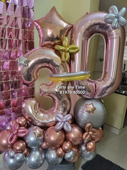 A large, impressive balloon bouquet for a 30th birthday, using rose gold and silver chrome balloons.