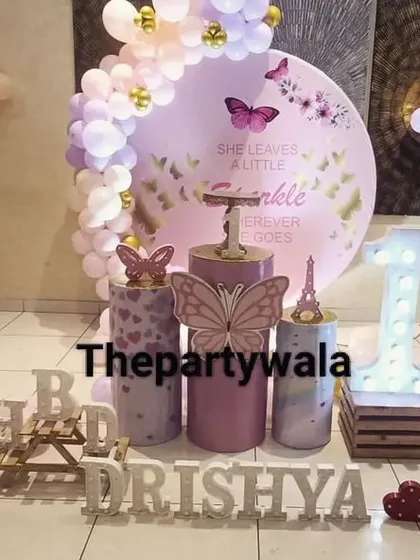 A whimsical fairy and butterfly theme with cute character cutouts and a soft purple color scheme.