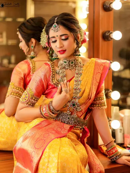 A quiet moment of reflection before a traditional bridal shoot. Using the mirror adds depth to the portrait, capturing both the model's elegant profile and the intricate details of her jewelry and saree.