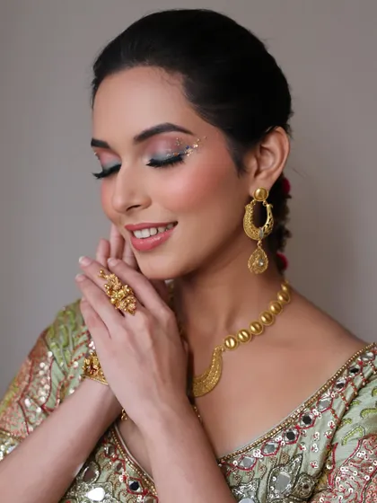 A moment of serene beauty. This shot highlights the flawless skin and the creative eye makeup, showing how the look is both festive and elegant.