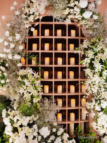 A stunning wall of candles set within a wooden grid and surrounded by white lilies and gypsophila. This architectural feature served as both a light source and a beautiful decor element.