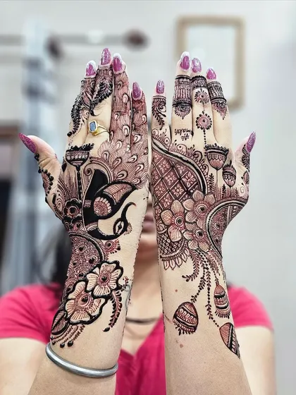 Here I created two different but coordinated back-hand designs for a client. One hand features a peacock motif, while the other has a floral mandala, showing my range in style.