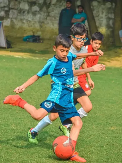 A young player takes a shot with an orange ball.
