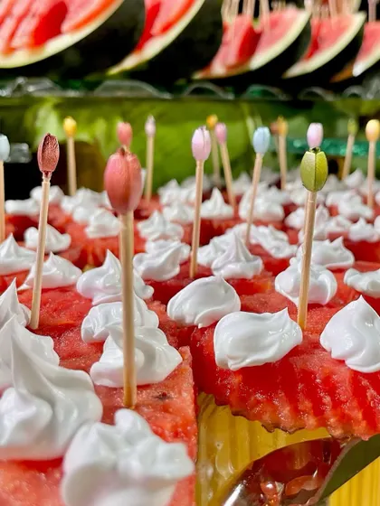 A creative presentation of watermelon cubes topped with whipped cream and decorative picks. It's the small details that make a display special.