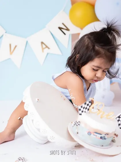 A moment of intense focus as he lifts the entire cake stand. You never know what a baby will do next, and my job is to be ready to capture these hilarious and strong-willed moments.