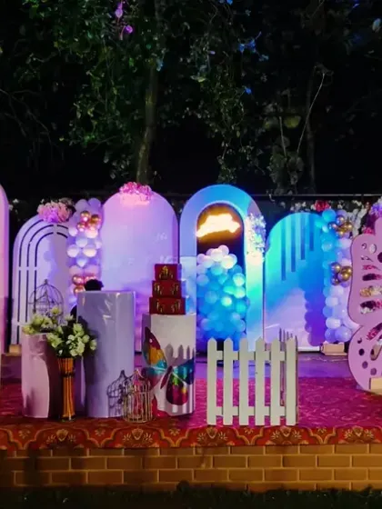 This butterfly-themed birthday setup looks especially magical at night. The glowing arches and large, pink butterfly wings create a beautiful photo backdrop for an evening celebration.