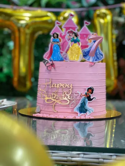A cake fit for royalty. This beautiful pink birthday cake features several Disney princesses, perfect for a magical princess-themed celebration.