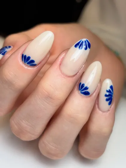 The full set of the minimal cobalt blue nails. The placement of the art at the base of the nail is a unique and stylish touch.