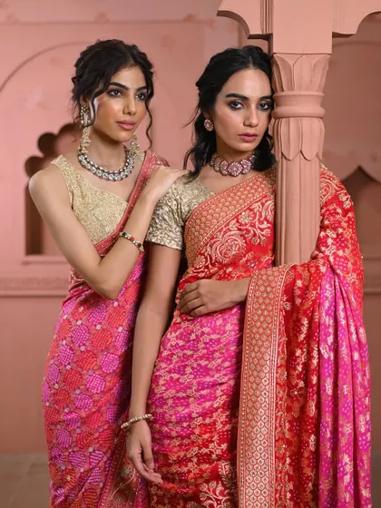 Styling for two. I often help coordinate looks for sisters or friends attending an event together, selecting complementary sarees like this pink bandhani and red brocade that share a similar aesthetic while allowing individual styles to shine.