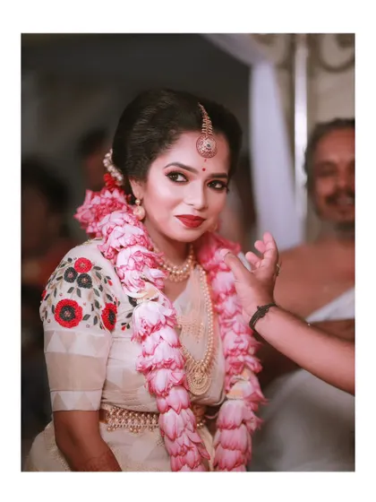 A beautiful close-up of the bride during her wedding ceremony, a gentle hand adjusting her garland.
