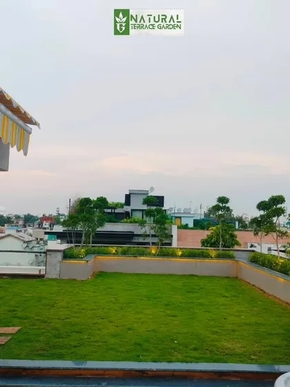 A view across the lush, natural grass lawn of our New Friends Colony project, with the city skyline in the background.
