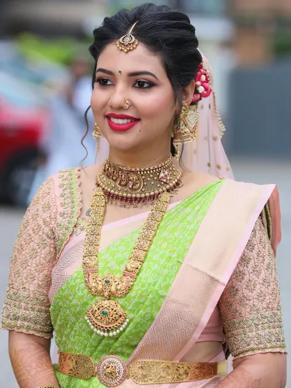 This bride's smile says it all. Her pastel green and pink Kanjivaram was paired with a custom blouse featuring delicate, all-over embroidery for a soft, elegant look.