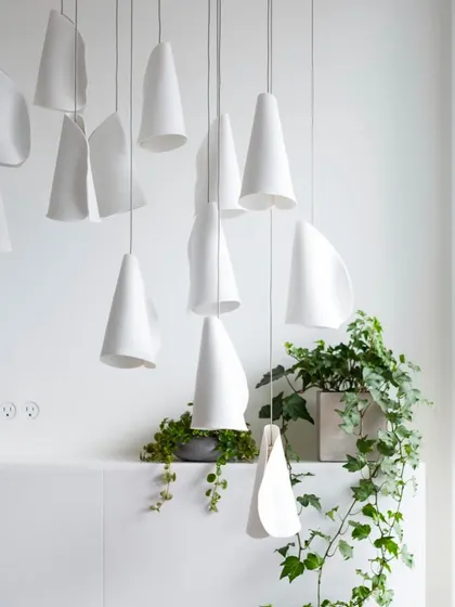 The Bocci 21 pendants in their unlit state, showcasing their pure white, sculptural forms against a clean backdrop. They function as art objects even when turned off.