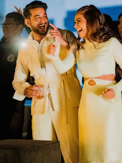 A happy couple at their party. The bride's modern hairstyle allows her to have fun without worrying about her hair.