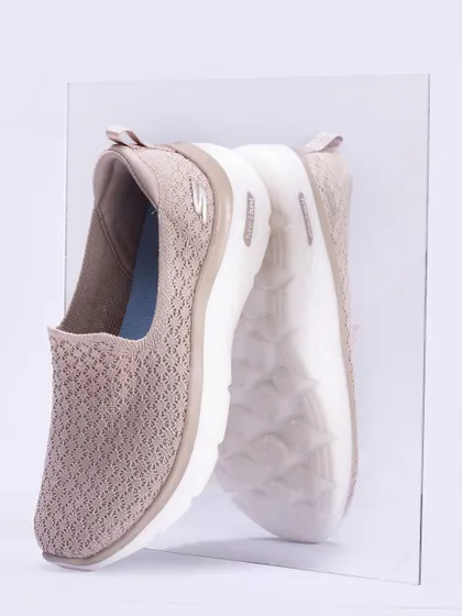 A side-profile shot of a Skechers Go Walk shoe pressed against a sheet of glass, showing its reflection. This angle highlights the shoe's silhouette and sole design, offering a unique and detailed perspective.
