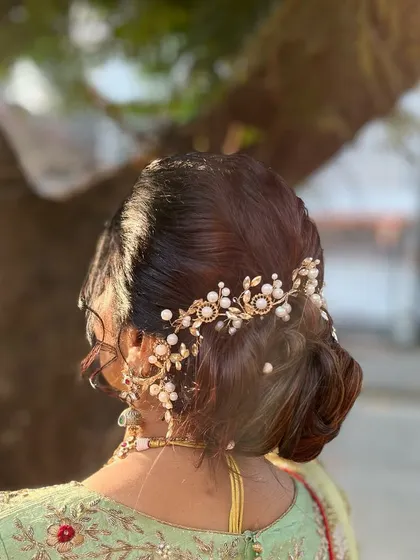A sophisticated low bun with a beautiful hair accessory. This is a great option for a classic and timeless wedding guest look.