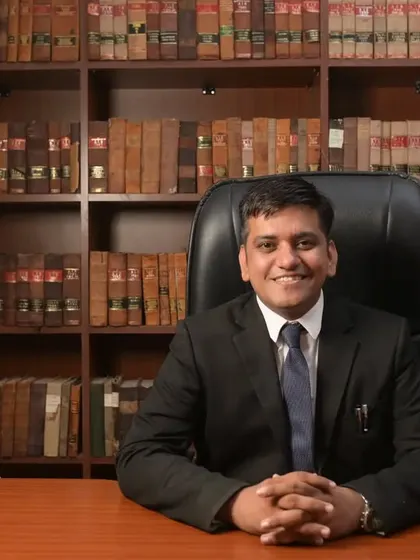 A portrait from my office. My practice is built on a foundation of deep legal knowledge, represented by the law library behind me.