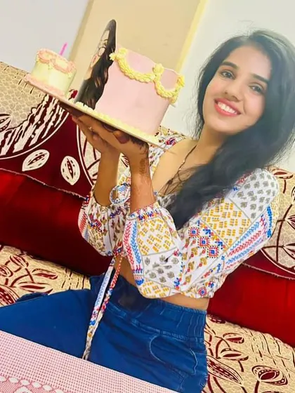 Holding her custom cake with a big smile. These are the moments we cherish.