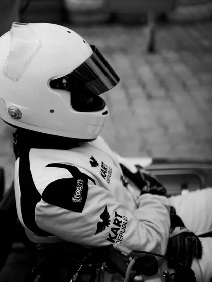 A black and white portrait of a driver in a moment of quiet contemplation, showcasing the mental side of being a competitive athlete.