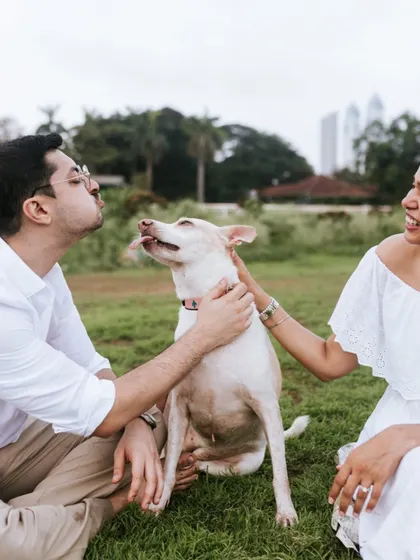 A playful and candid moment of the couple showering their dog with affection. These are the unposed, joyful moments that truly define a family's bond.