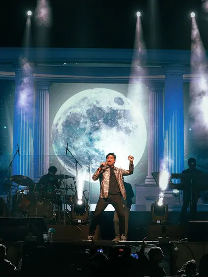 Singer Shaan performing on a grand stage with a full moon visual, a signature of our high-quality production design at Srijan, IIT Dhanbad.