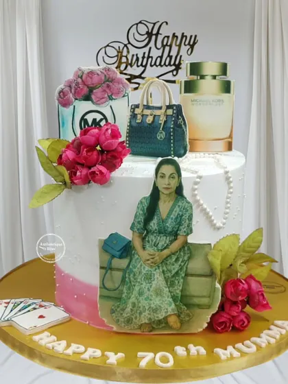 An elegant shopper-themed cake featuring Michael Kors products. This pineapple cake includes an edible portrait and details like playing cards to reflect the recipient's hobbies.